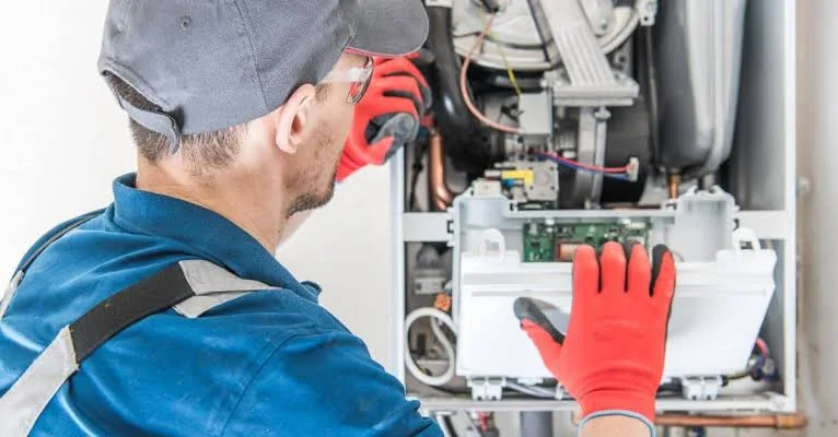 Technician inspecting indoor HVAC equipment for installation service
