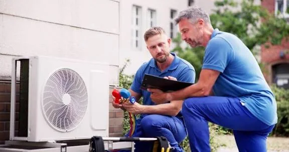 Two HVAC technicians reviewing residential equipment installation