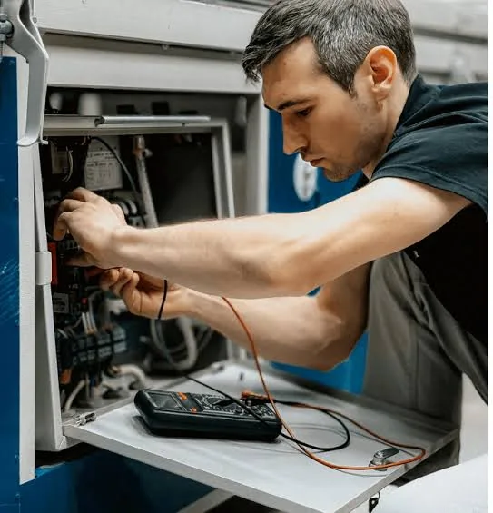 Technician using a meter during HVAC maintenance