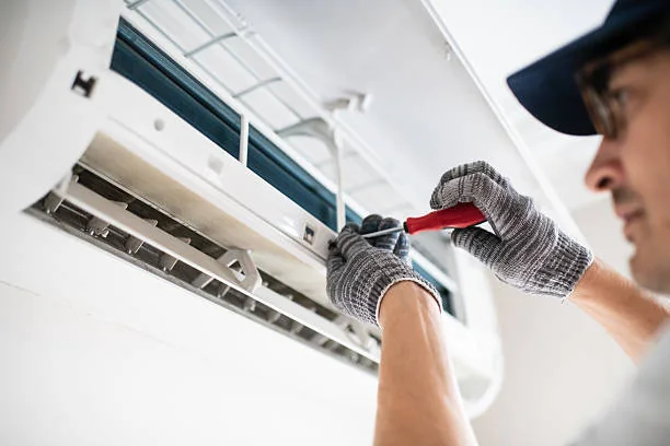 Technician cleaning an indoor air conditioning filter