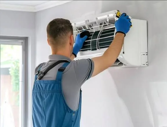 Technician servicing a wall-mounted residential climate system